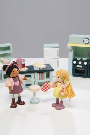 Two toy dolls in a kitchen setting with a gray background