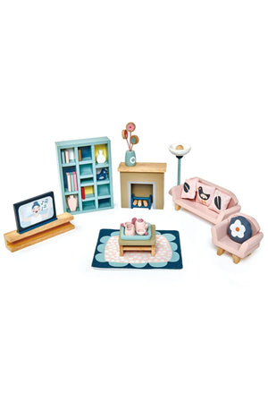 A colorful wooden dollhouse sitting room set featuring a sofa, armchair, coffee table, lamp, fireplace, and bookshelf.
