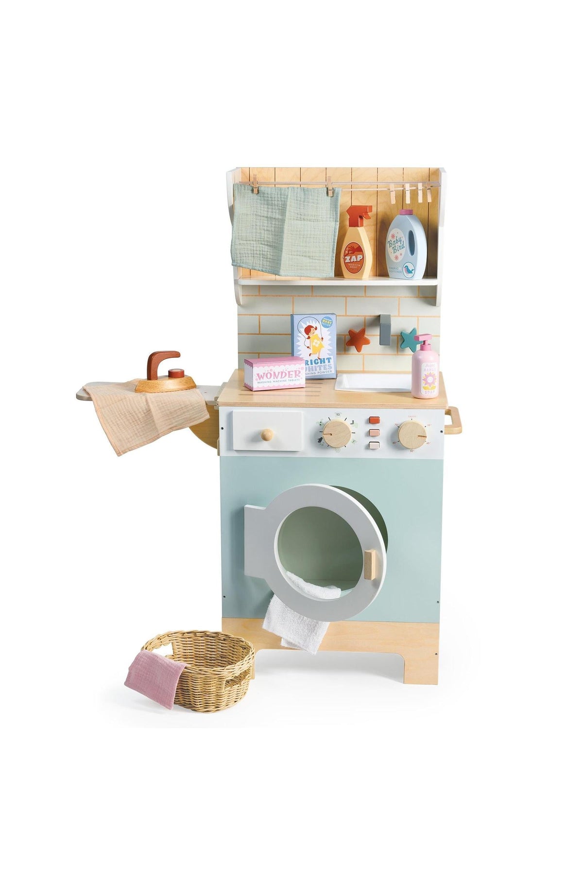 A charming wooden laundrette toy features a pastel blue washing machine, shelves with accessories, and a wicker laundry basket, promoting imaginative play for young children. Ideal for eco-conscious families.