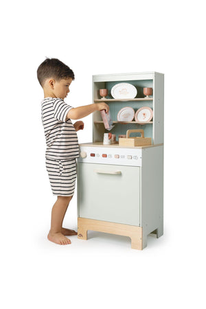 Child playing with a toy kitchen set on a white background