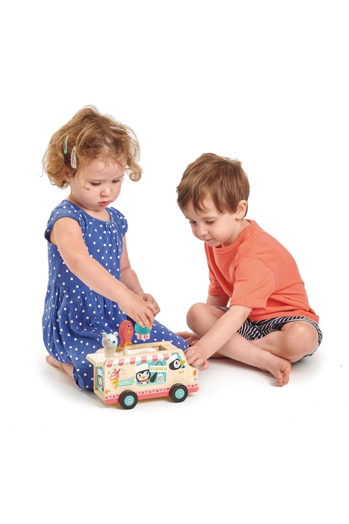 Two children play with a colorful wooden gelato van toy, featuring penguin characters and removable ice cream cones.