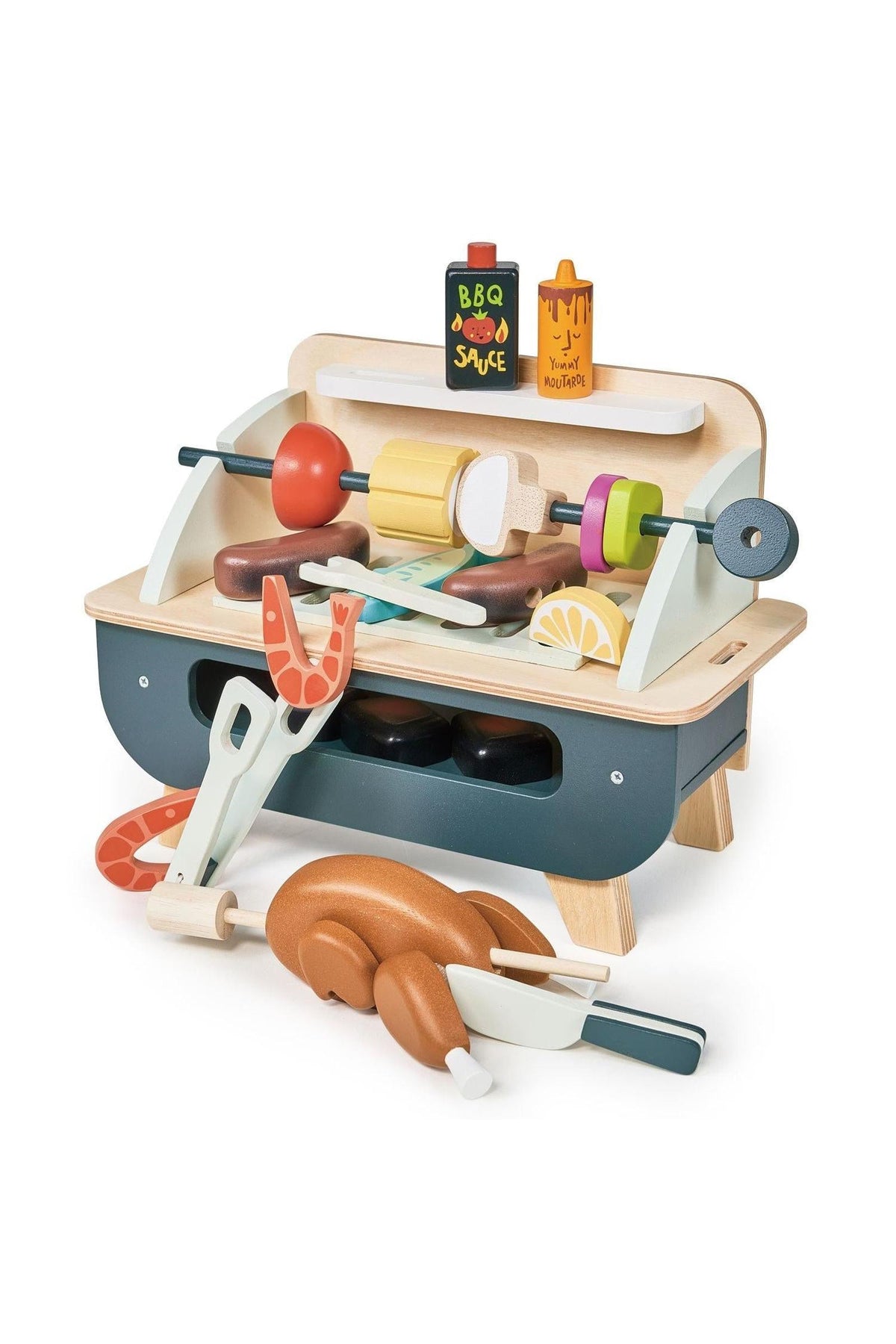 A colorful wooden barbeque play set features a self-standing grill with various accessories, including sausages, a chicken, vegetables, and pretend sauce bottles, all crafted from eco-friendly materials.