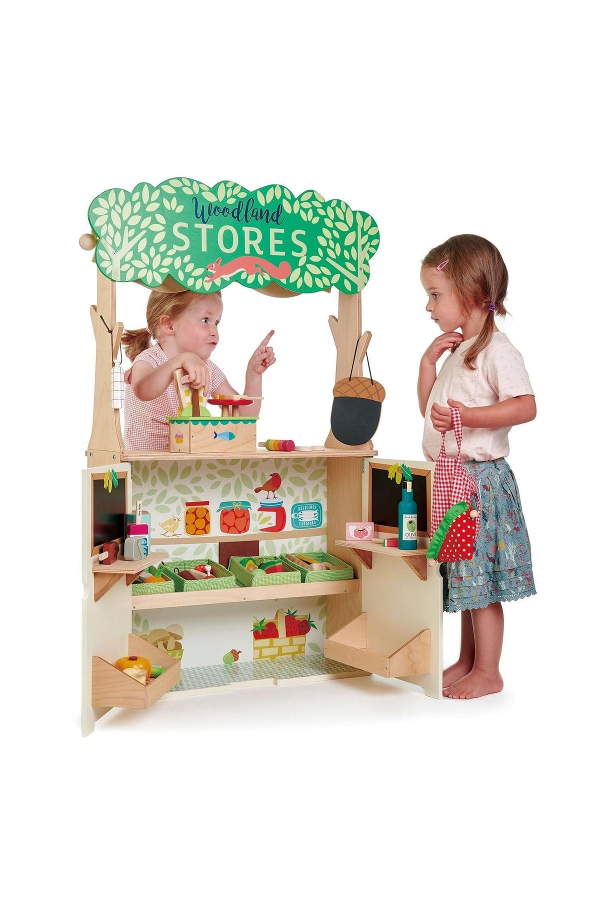 Two children play with the Tender Leaf Wooden Toys Woodland Stores set, featuring colorful shelves and accessories.