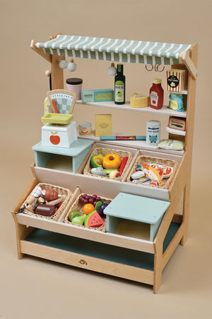 Wooden market stall featuring sturdy shelves, baskets of colorful play food, and a striped fabric canopy, ideal for imaginative play.