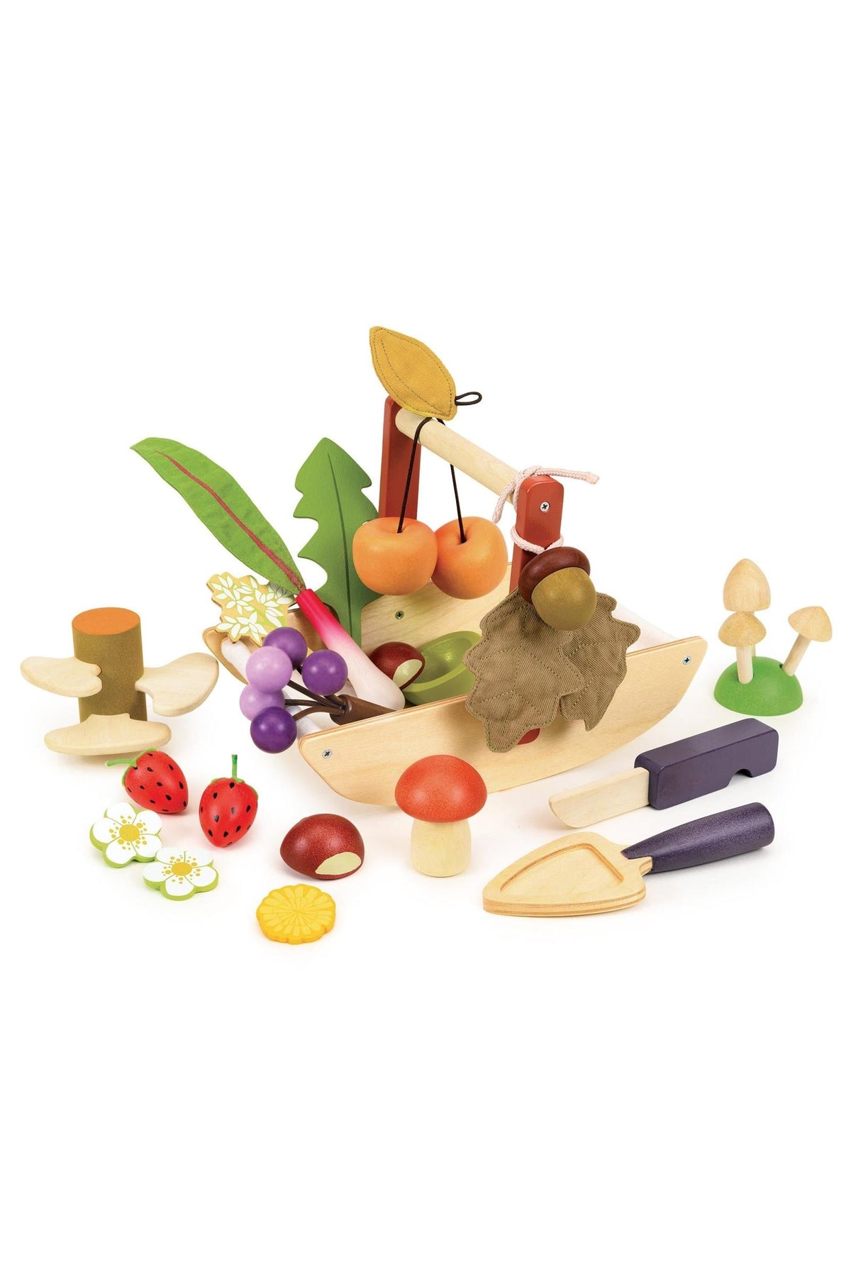 A colorful collection of wooden fruits, vegetables, and tools arranged around a boat-shaped trug, designed for imaginative play.