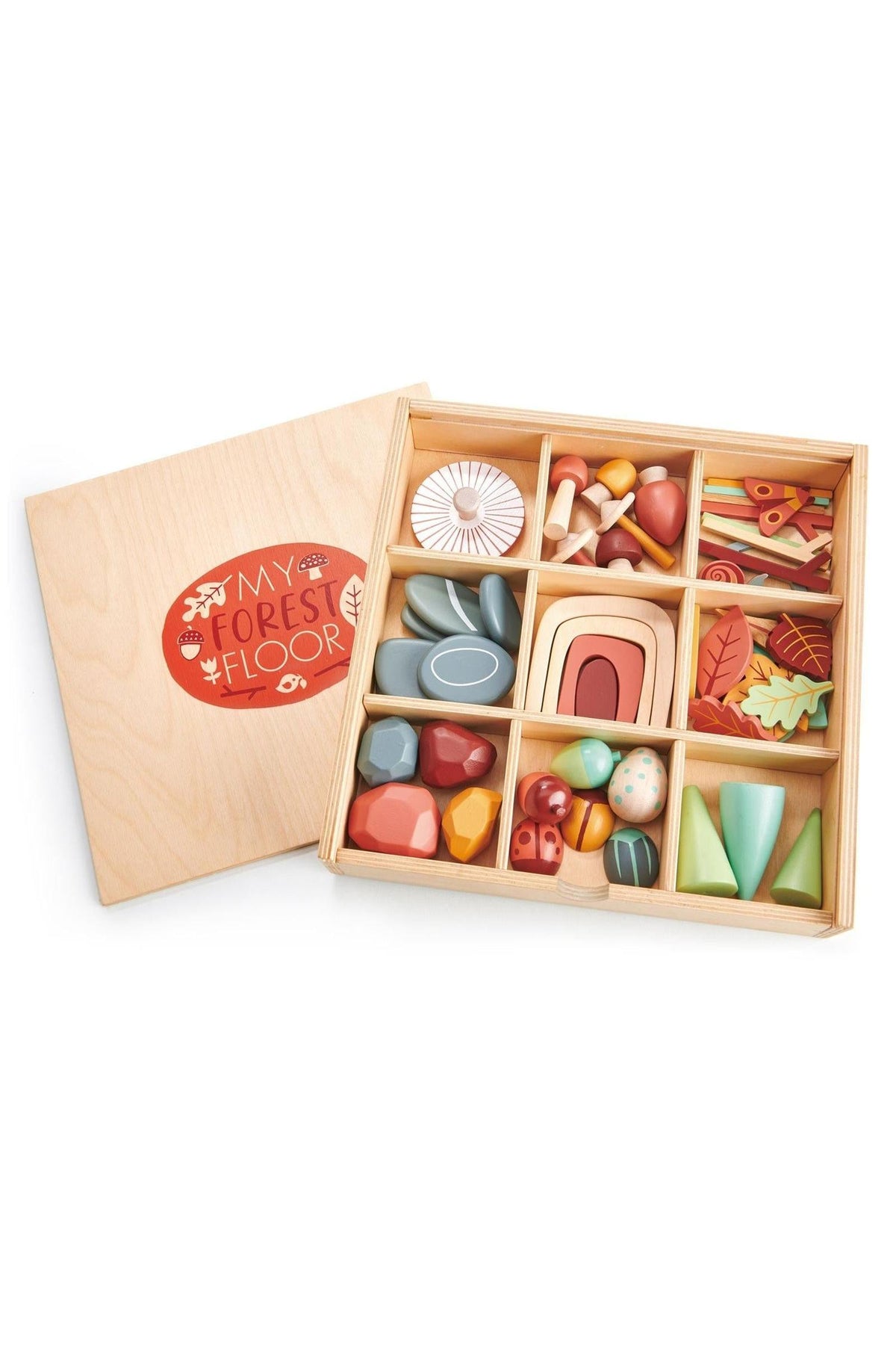A wooden tray filled with colorful, handcrafted toys representing forest elements, including leaves, mushrooms, and stones. The tray features a vibrant design and promotes imaginative play for children.