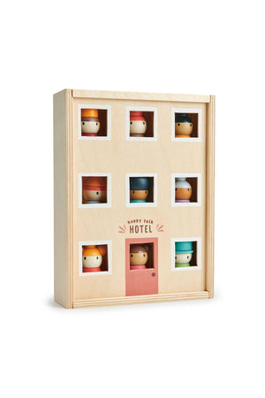 A wooden hotel toy features colorful, smiling characters peeking through square windows, promoting imaginative play for children.