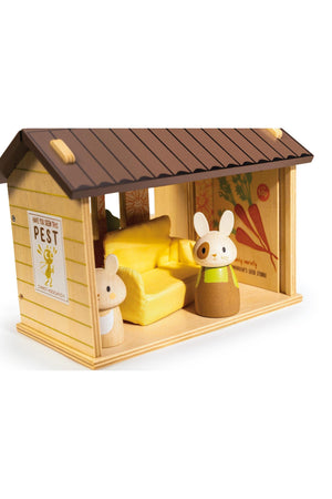 A wooden playset features a cozy shed with a brown roof and yellow interior, accompanied by two adorable bunny figures. This eco-friendly toy encourages imaginative play for young children.