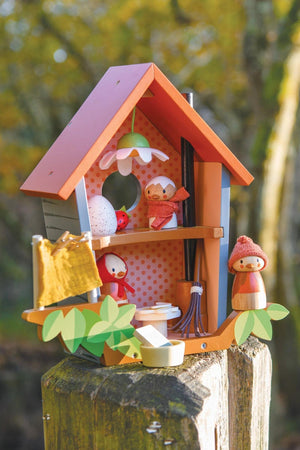 Wooden birdhouse toy with red roof, polka dot interior, and bird figures. Features washing line and leaf details.