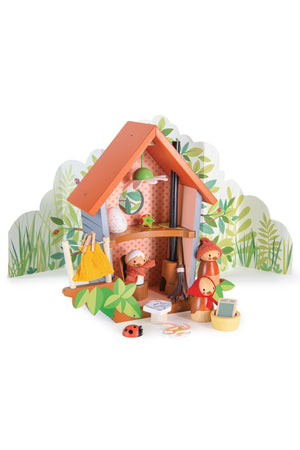 Colorful wooden playhouse with bird figures, leaf decorations, and a backdrop of greenery. Sustainable, family-friendly toy set.