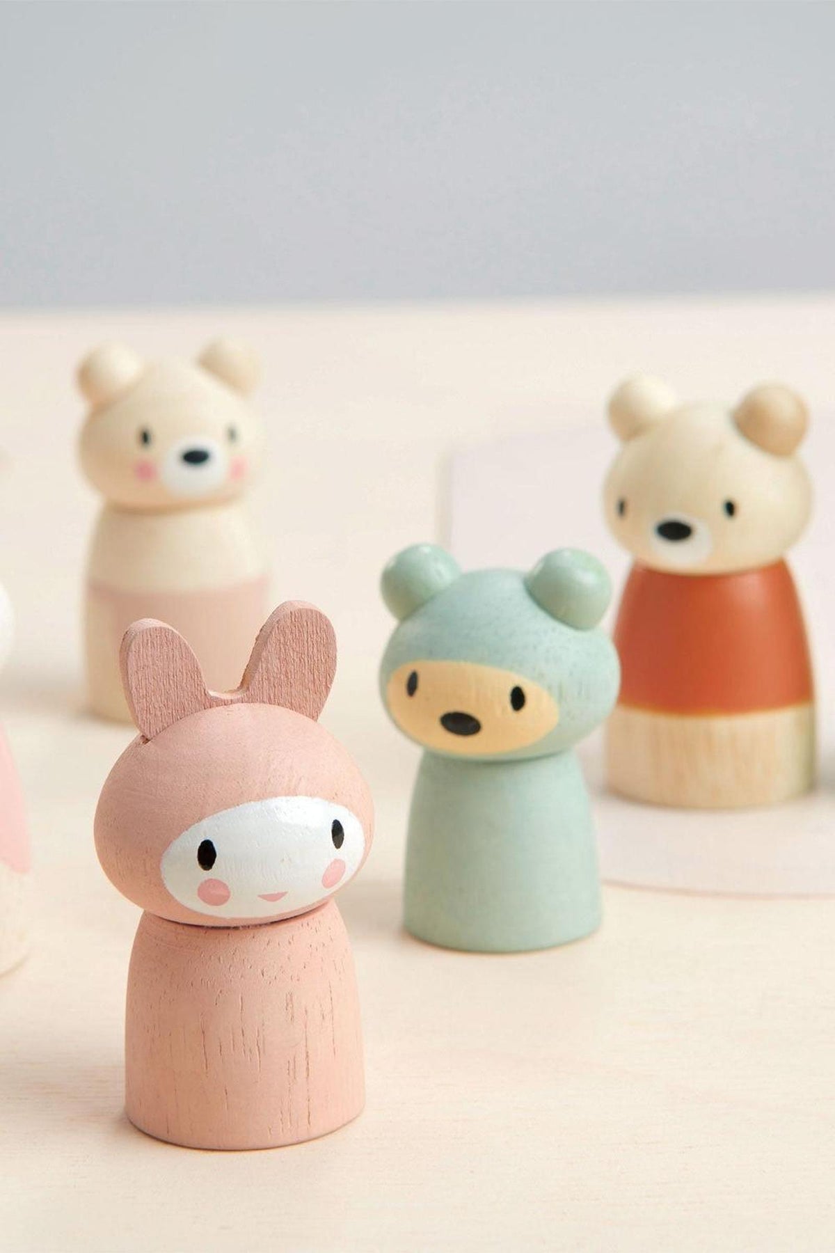 A colorful set of wooden animal figurines, featuring a pink bunny and green bear, designed for imaginative play.