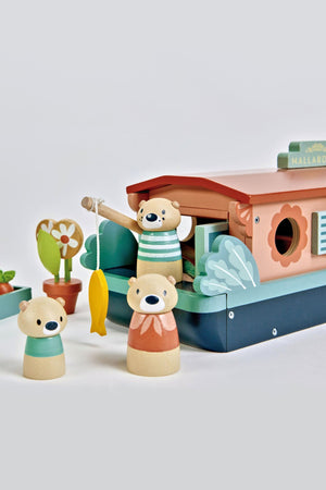 A colorful wooden toy canal boat named Mallardeau features a family of playful otters, a fishing rod, and potted plants, all crafted with eco-friendly materials for imaginative play.