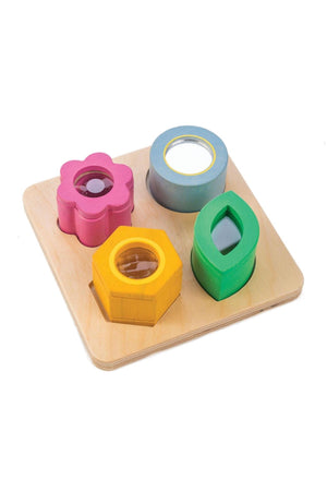 Wooden sensory tray with colorful shapes: pink flower, blue circle, yellow hexagon, and green leaf on a wooden base.