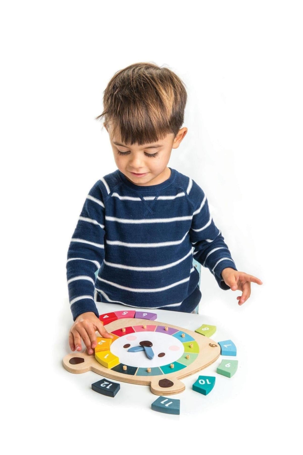 A young child in a striped blue sweater interacts with a colorful wooden math toy featuring numbers and a spinning wheel.