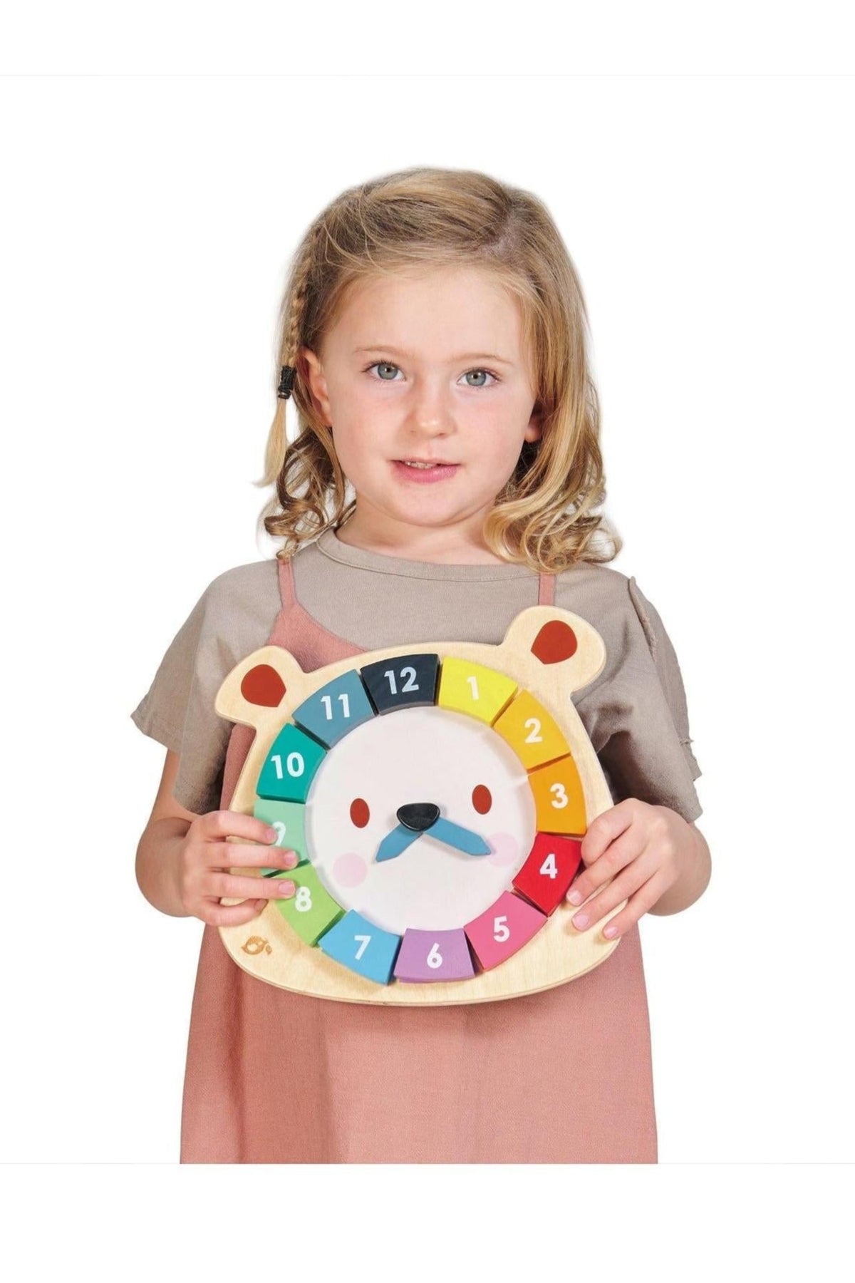 A young girl holds a colorful wooden bear-shaped clock with numbers around its face. The clock features a cheerful bear design and is made from sustainable materials.