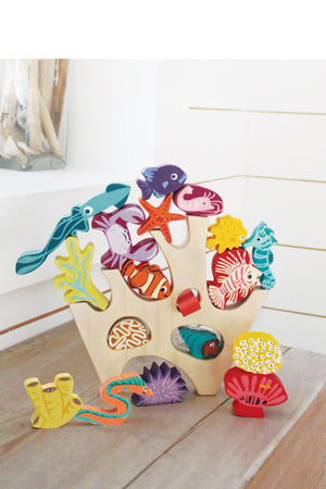Colorful wooden sea creatures and coral pieces are displayed on a light wooden base, showcasing vibrant designs and shapes.