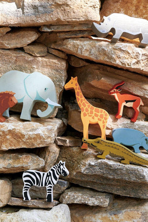 Colorful wooden animal figures, including an elephant, giraffe, and lion, are displayed on a stone backdrop, showcasing the Tender Leaf.