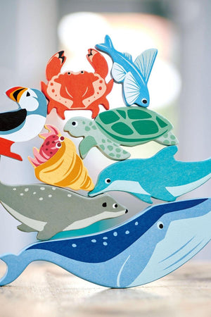A colorful wooden toy display features various coastal creatures, including a whale, dolphin, sea turtle, and crab, highlighting sustainable craftsmanship.
