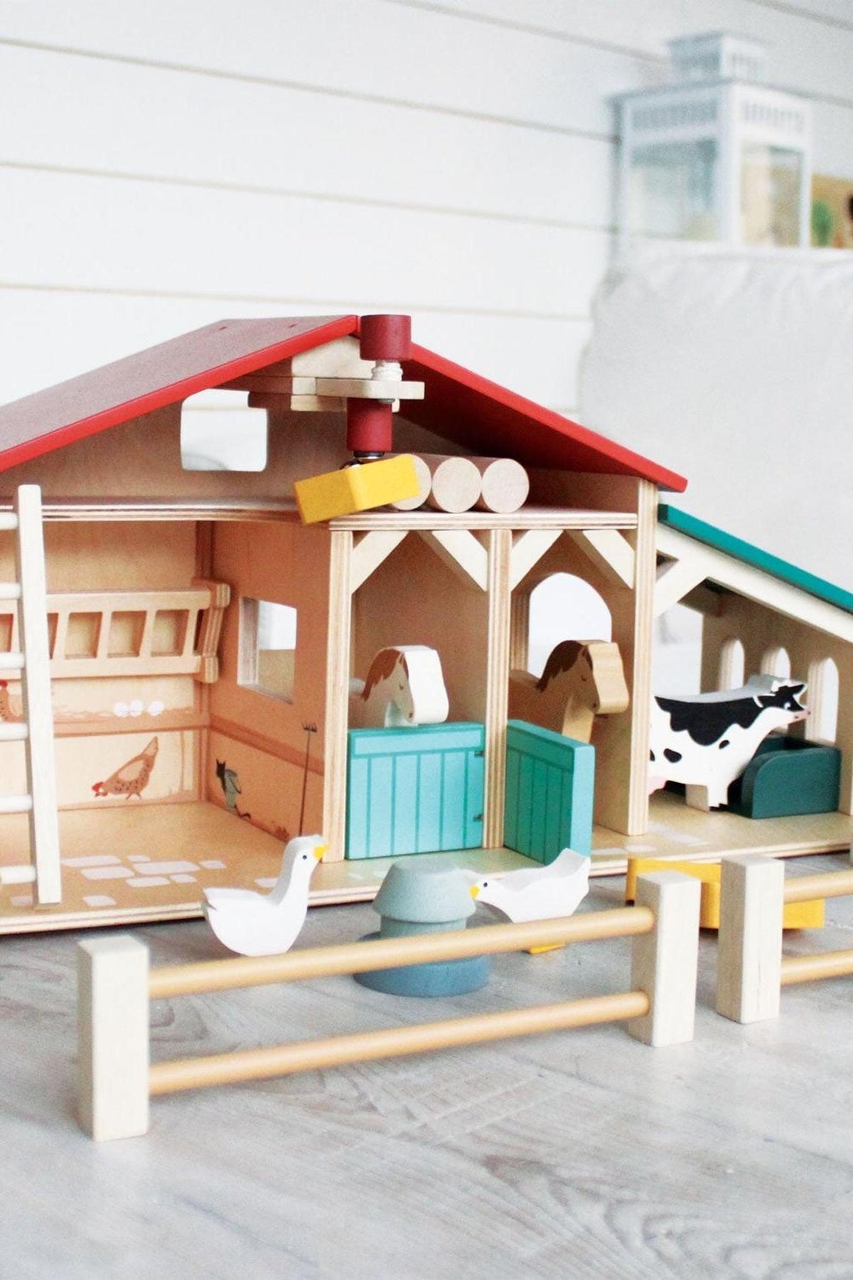 A colorful wooden toy farm with a barn, stables, and animals, made from sustainable materials for imaginative play.