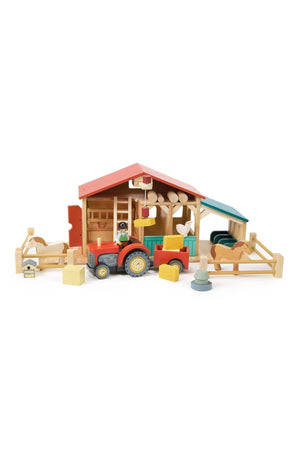A colorful wooden barn set featuring a red tractor, farm animals, and various play pieces, ideal for imaginative play.