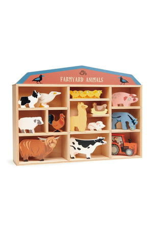 A wooden display shelf showcases a collection of colorful farmyard animal toys, including a cow, pig, and sheep, highlighting sustainable materials and playful design for children aged three and older.