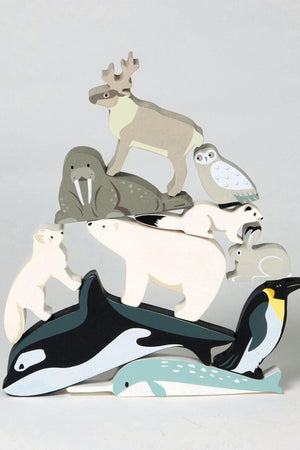 A wooden toy display features various polar animals, including a polar bear, walrus, and penguin, in soft colors.