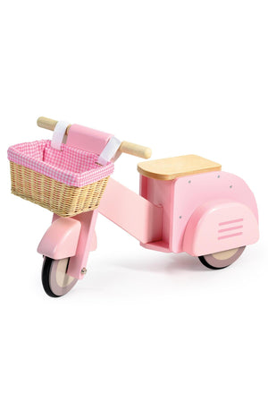 Pink wooden ride-on scooter with a wicker basket lined in pink gingham, featuring a wooden seat and sturdy wheels.