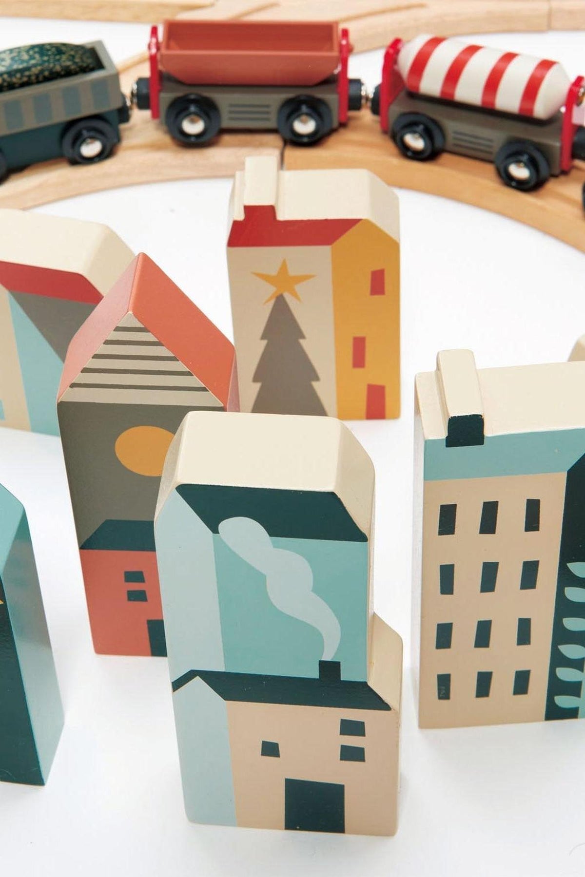 Colorful wooden buildings in various shapes and designs are arranged on a white surface, showcasing a modern aesthetic.