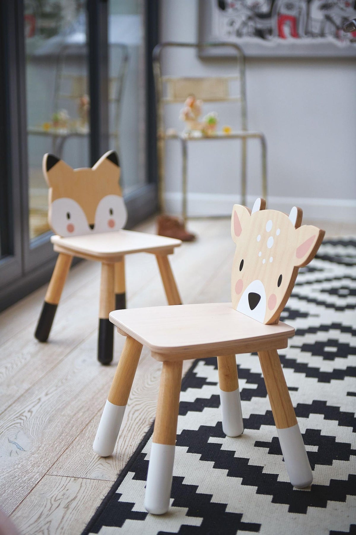 Two playful toddler chairs feature animal designs—one with a fox and the other with a deer—set on a patterned rug.