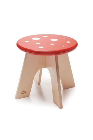 Red toadstool-shaped stool made from solid wood, featuring a polka-dotted top and four sturdy legs, ideal for toddlers.