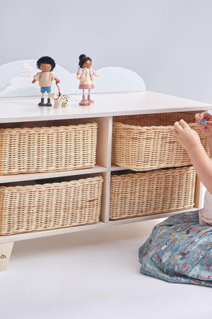 A child plays near a wooden storage unit with four wicker baskets and two toy figures on top.