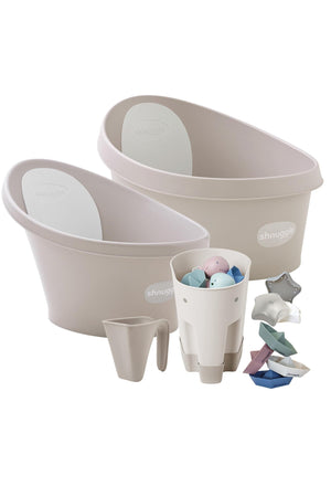 Shnuggle bath bundle includes beige baby baths, a cup, and colorful toys, designed for newborns and toddlers.