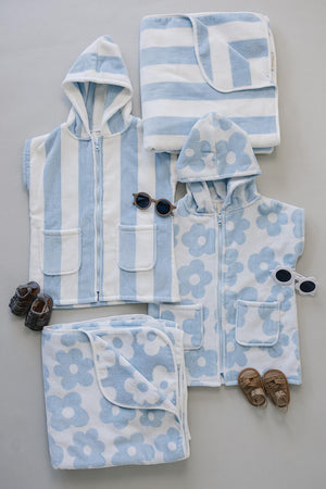 A collection of light blue and white beach towels and hooded ponchos made from soft, absorbent fabric.