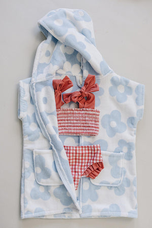 Light blue and white floral zip-up beach poncho made from soft organic cotton, featuring a cozy hood and two front pockets.