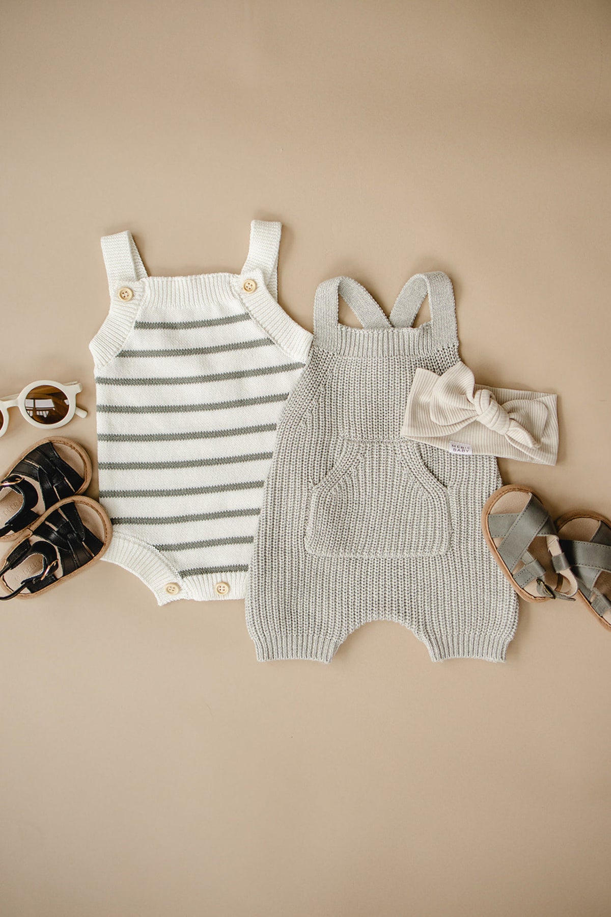 Gray knit overalls and striped romper with sandals, sunglasses, and a headband on a beige background.