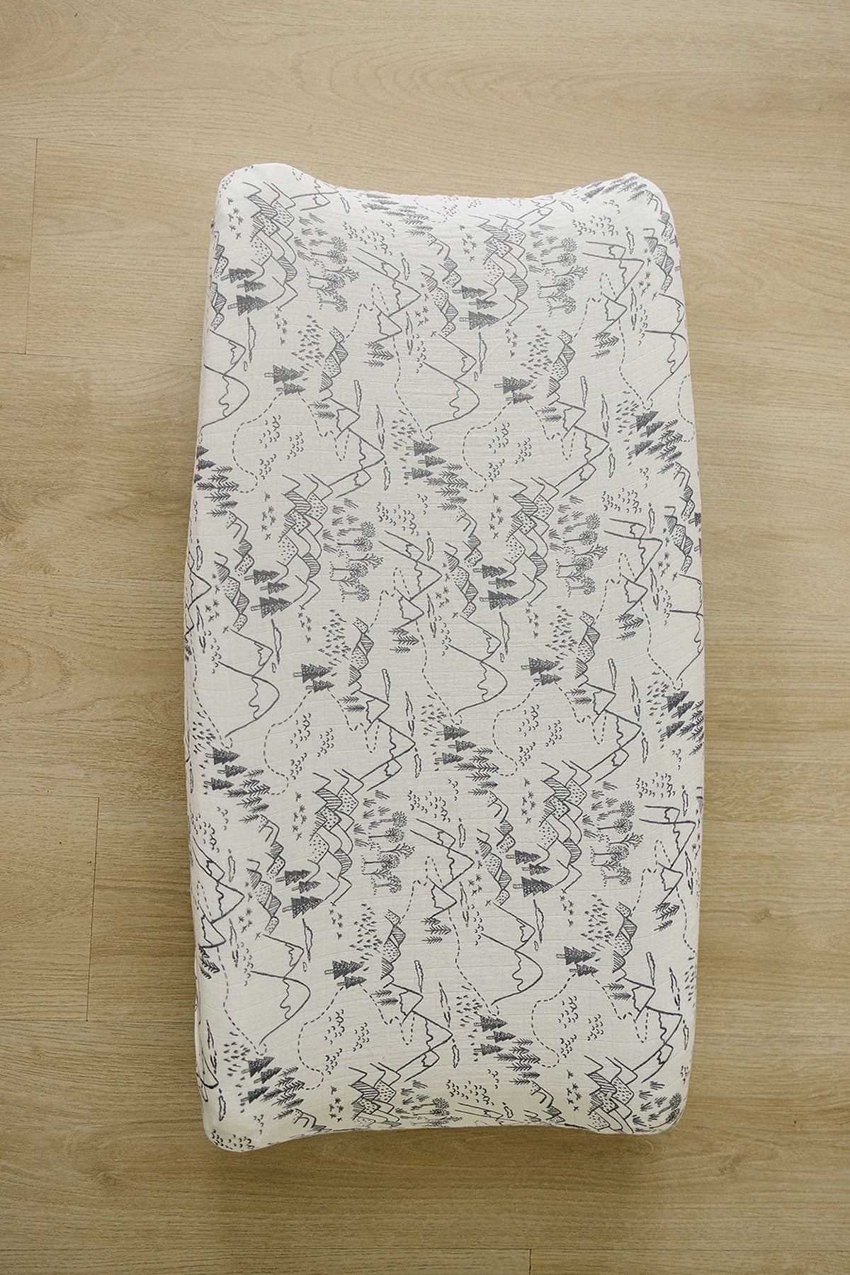 Muslin changing pad cover in a soft, breathable cotton features a charming, nature-inspired pattern in gray on a cream background. Perfectly fits standard changing pads for stylish nursery decor.