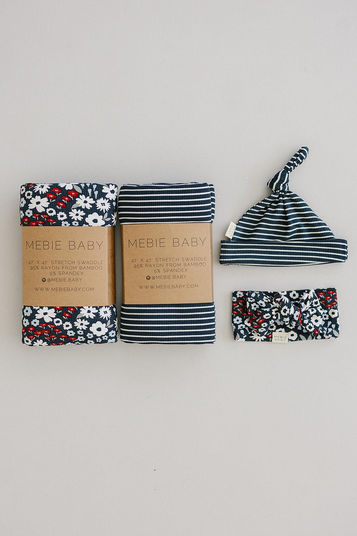 Two Mebie Baby swaddles, a striped hat, and a floral headband, all made from bamboo fabric.