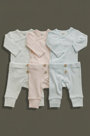A set of four baby layette outfits in soft, breathable cotton, featuring pastel colors: light blue, pink,.