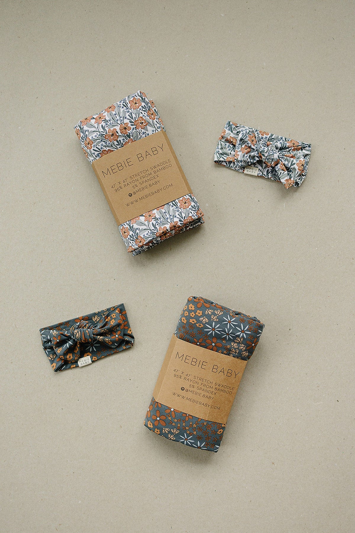 Mebie Baby floral swaddles and headbands on a beige background, featuring orange flowers on bamboo fabric.
