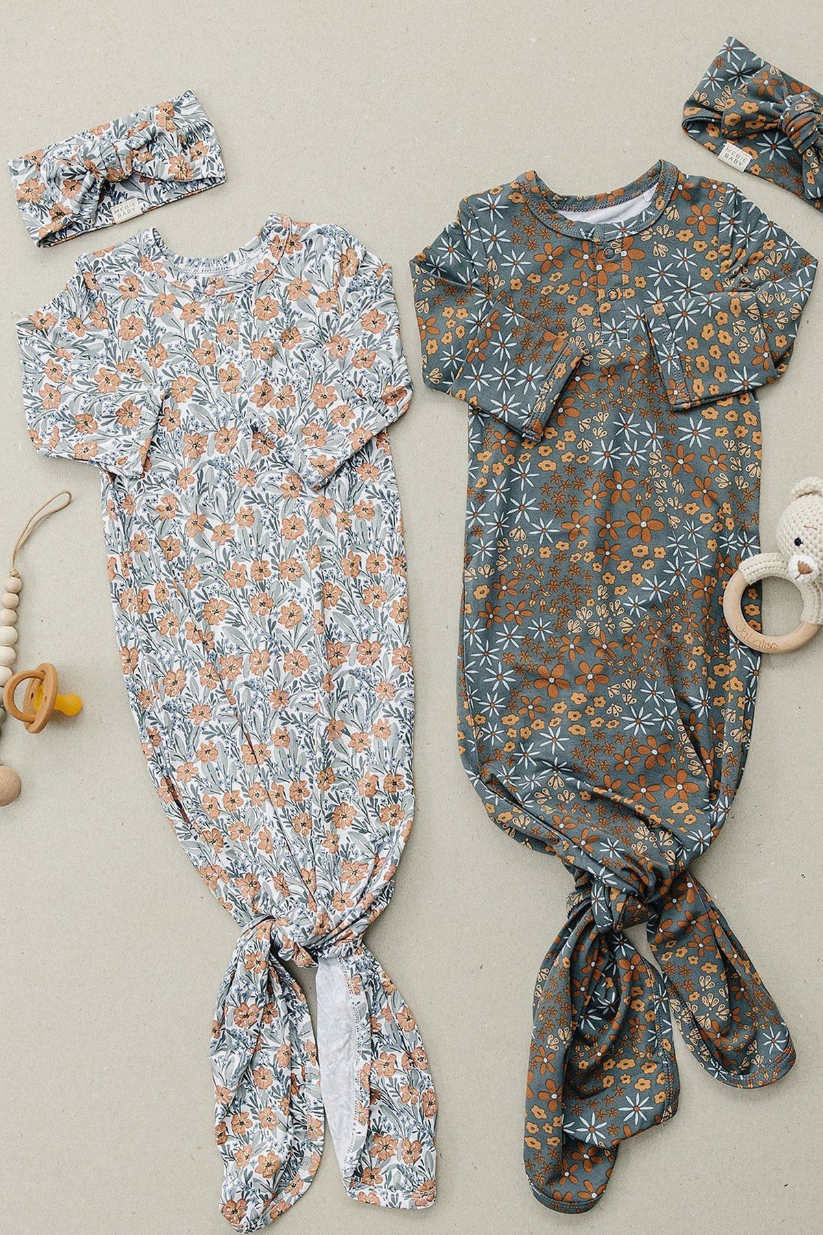 Two floral baby knot gowns in navy and white with matching headbands, displayed on a neutral background.