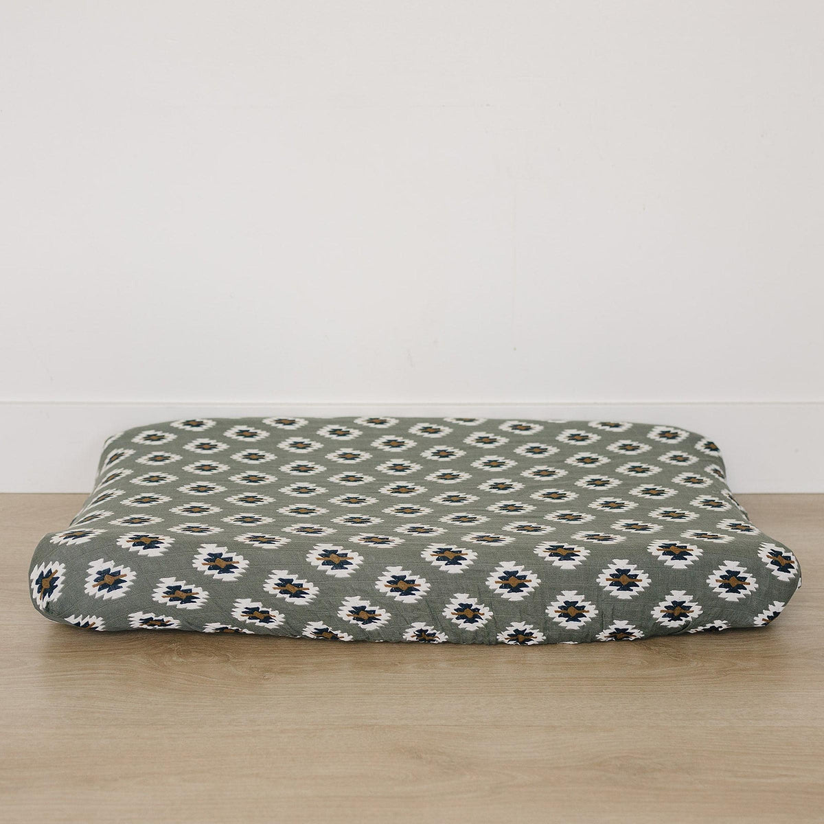 A soft muslin changing pad cover featuring a Southwest Aztec design in earthy tones, perfect for adding a modern western touch to nursery decor.