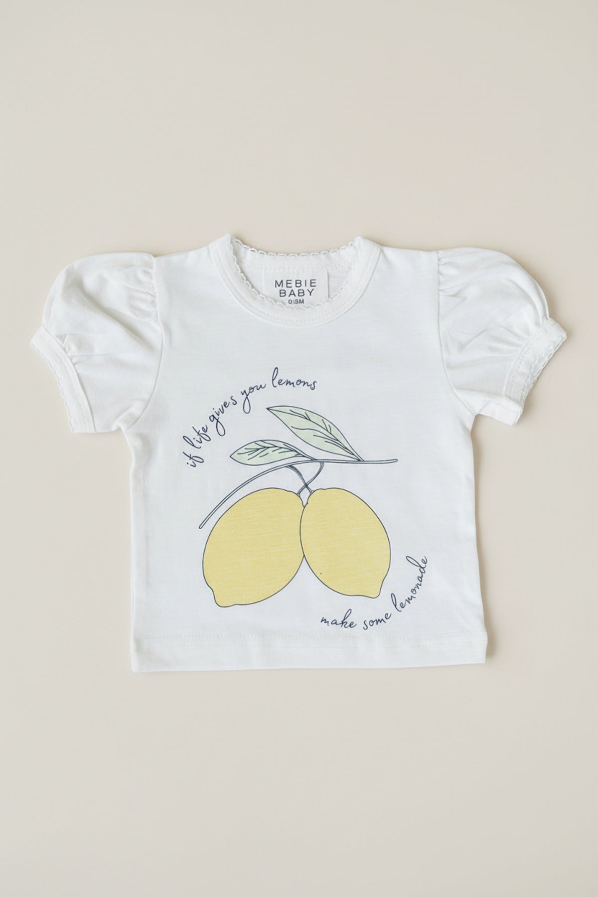 White cotton short-sleeve t-shirt featuring a playful lemon graphic and text that reads, If life gives you lemons, make some lemonade. Ideal for young girls, combining charm and comfort.