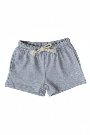 Soft grey cotton shorts featuring an elastic waistband with a drawstring and side pockets, perfect for kids play. Ideal for all-day comfort and versatile styling options.