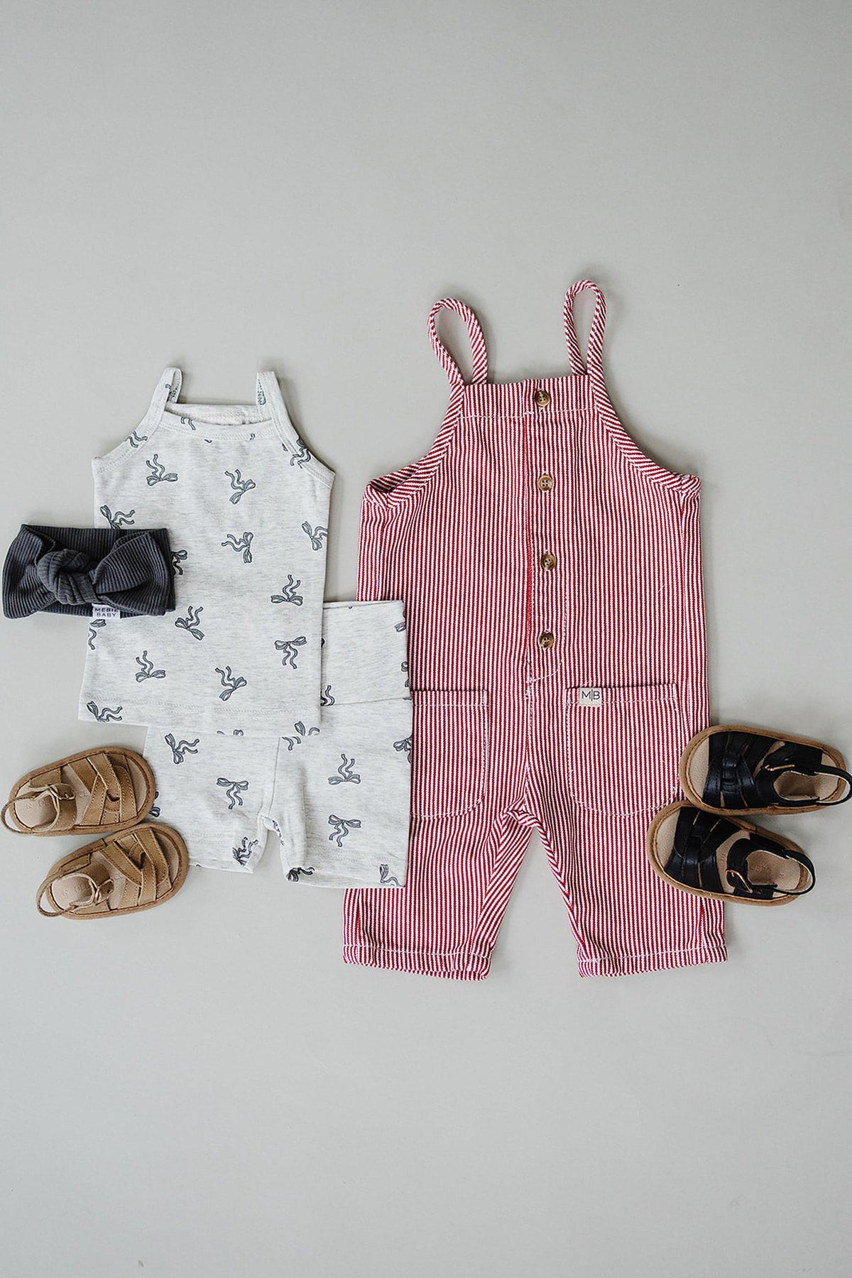 Gray bow-patterned tank and shorts set with sandals beside a red-striped romper and black sandals.