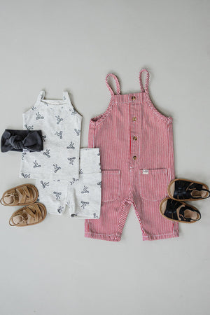 Gray bow-patterned tank and shorts set with sandals beside a red-striped romper and black sandals.