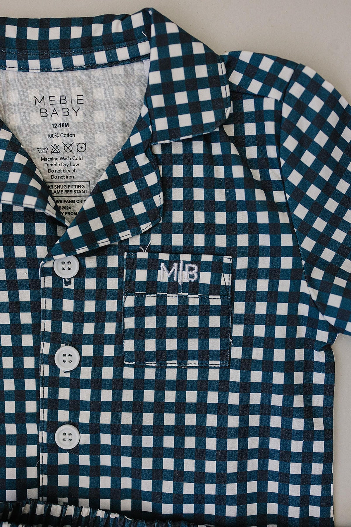 Navy gingham short-sleeve shirt with white buttons and a pocket, embroidered with MB on the chest.