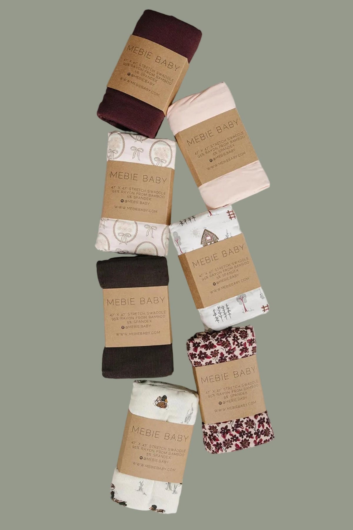 A collection of seven rolled fabric swaddles from Mebie Baby, featuring various pastel colors and playful patterns, displayed on a light surface. These soft, breathable swaddles are ideal for newborns.