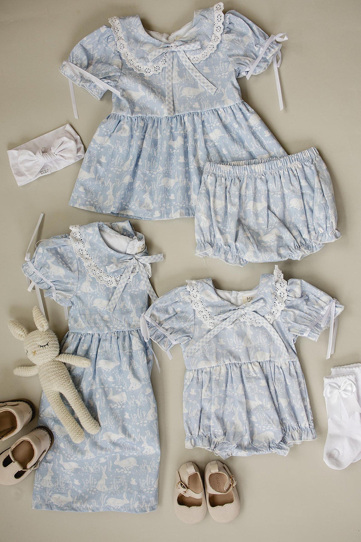 Light blue dresses with bunny graphics, featuring Peter Pan collars, lace details, bows, matching bloomers, shoes, and headbands.