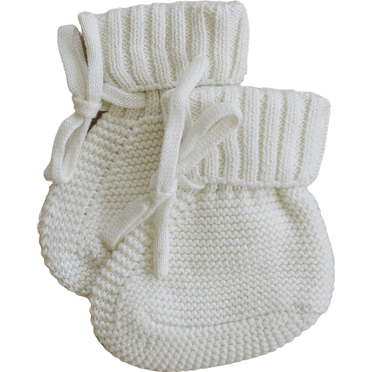 Soft, white knit cotton baby booties feature a cozy design with a ribbed cuff and ties, perfect for keeping tiny toes warm and stylish for infants. Ideal for special occasions.