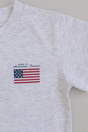 White cotton T-shirt featuring a small American flag graphic and Mebie Co. Americana Summer text on the front.